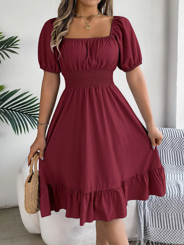 Robe à manches bouffantes et ourlet à la taille